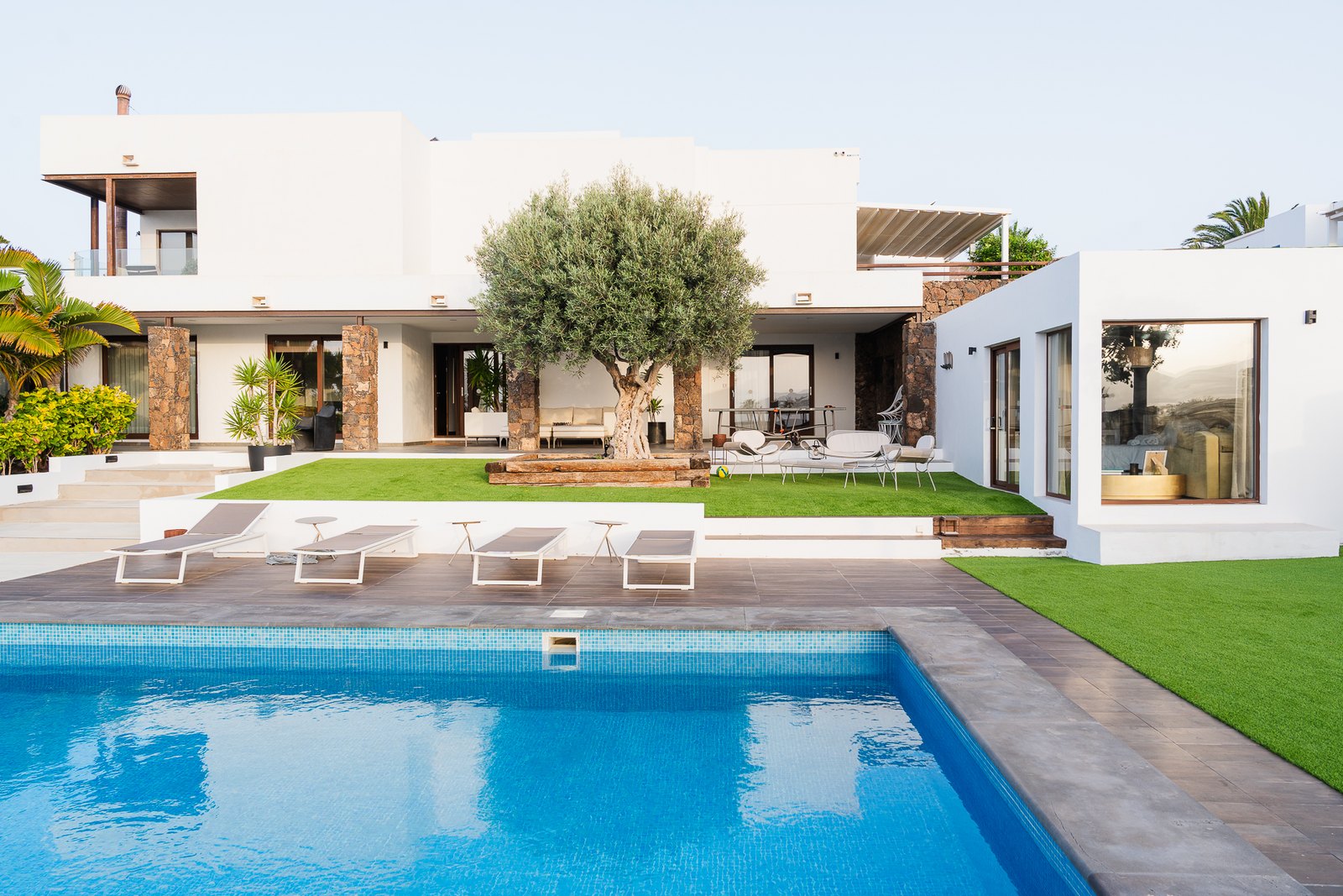 Two-level house around a patio, with four apartments and a large pool